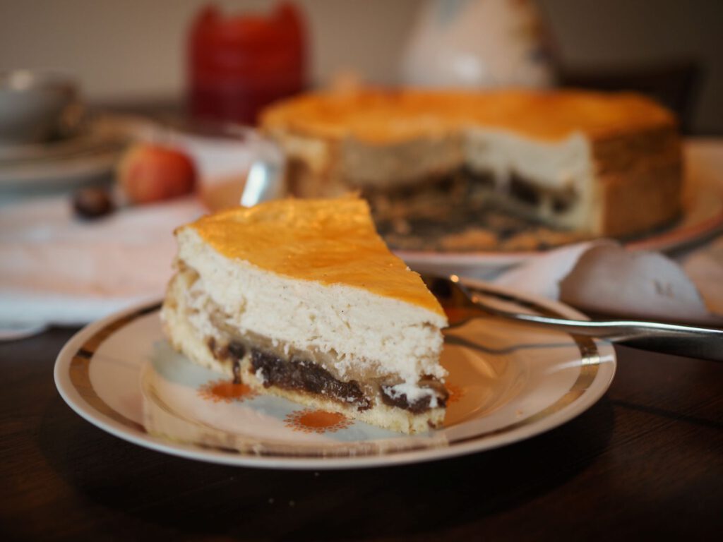 Anschnitt vom Böhmischen Käsekuchen mit Apfelstücken und Rosinen.
